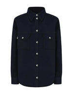 The Clapotis Berber Shirt by Blaze Milano is a long-sleeve, button-up black denim overshirt featuring a collar and two chest pockets with buttoned flaps, drawing on classic safari-style details for a timeless yet practical look.