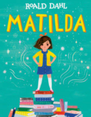 Illustrated cover of "Matilda" by Penguin Random House, showing a girl confidently standing on a stack of books against a teal, star-patterned background.