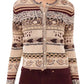A woman wears the Ulla Johnson Liza Cardigan, featuring earth tones and Fair Isle motifs, paired with high-waisted dark burgundy pants.