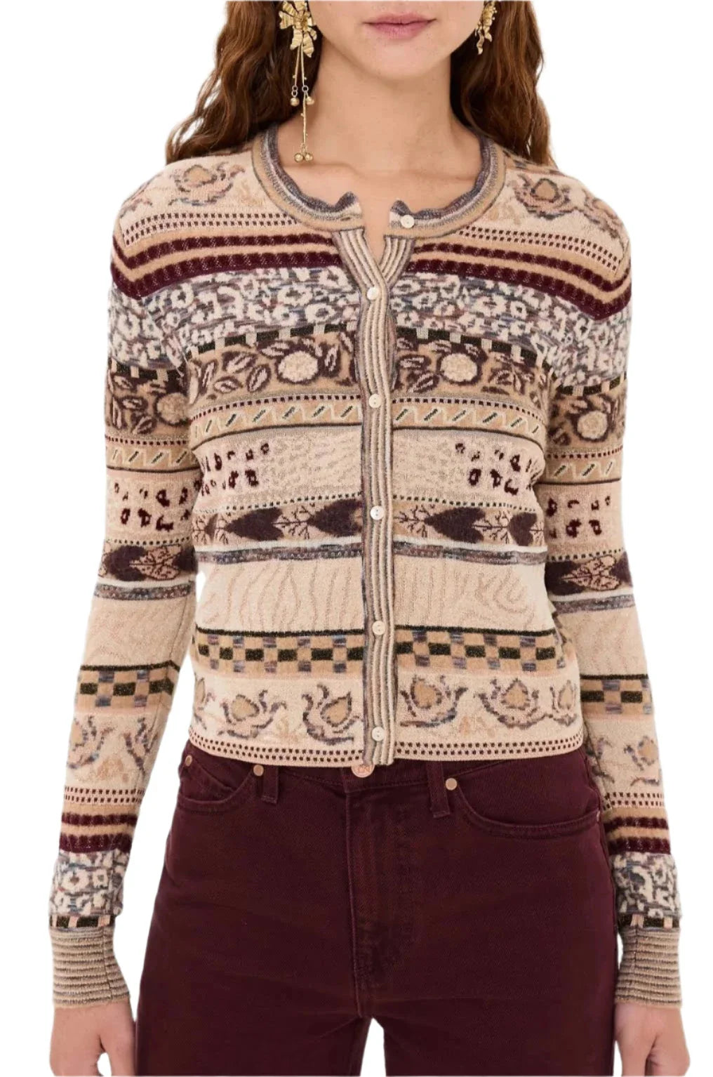 A person wearing an Ulla Johnson Liza Cardigan adorned with Fair Isle motifs and maroon pants.