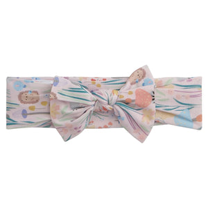 The Magnetic Me Baby Girls' Shroom and Bloom Modal Headband is a soft TENCEL™ modal accessory with a large bow, featuring pastel woodland animals and floral prints on a light background.