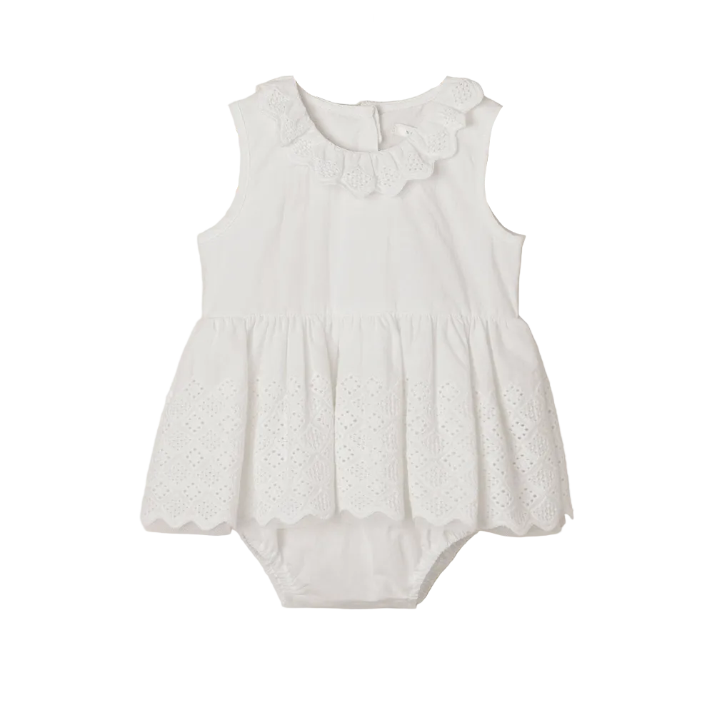 The Noralee Baby Girls’ Georgia Romper features a white sleeveless design with a scalloped collar and delicate eyelet detailing on the skirt, thoughtfully crafted for easy changing and presented against a plain white background.