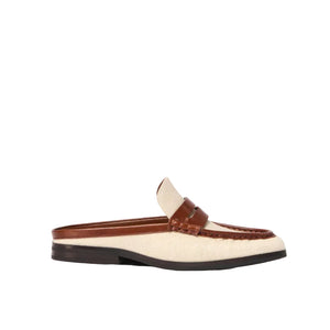 The Simkhai Dean Canvas Como Loafer Mule is a beige and brown backless slip-on loafer, crafted with a stitched leather upper and set on a low black sole, displayed against a white background.