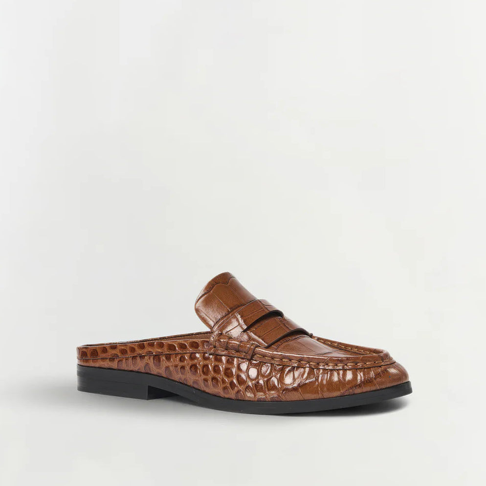 The Dean Leather Loafer Mule by Simkhai is a brown slip-on loafer mule crafted from croc-embossed leather, featuring a penny slot detail and a black sole, shown against a plain white background.