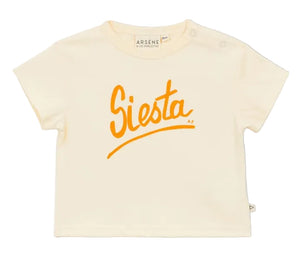 The Baby Siesta T-Shirt by Arsene & Les Pipelettes is a cream-colored, short-sleeved cotton tee featuring a breathable design and bold orange "Siesta" script printed across the chest.