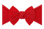 The Baby Bling Classic Knot Headband showcases a high-quality red fabric bow with a central knot, set against a crisp white background.