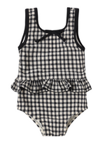 The Rylee & Cru Baby Girls' Skirted One-Piece features a black and white gingham print, a ruffle waist, and a small bow at the neckline. Displayed against a white background, this adorable romper blends classic style with comfort—perfect for pool days.