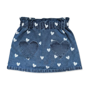 The Girls’ Teacher Skirt by Louis Louise features a playful blue denim design adorned with white heart prints and two oversized heart-shaped pockets on the front. Displayed against a white background, this charming A-line skirt adds a delightful touch to any girl’s outfit.