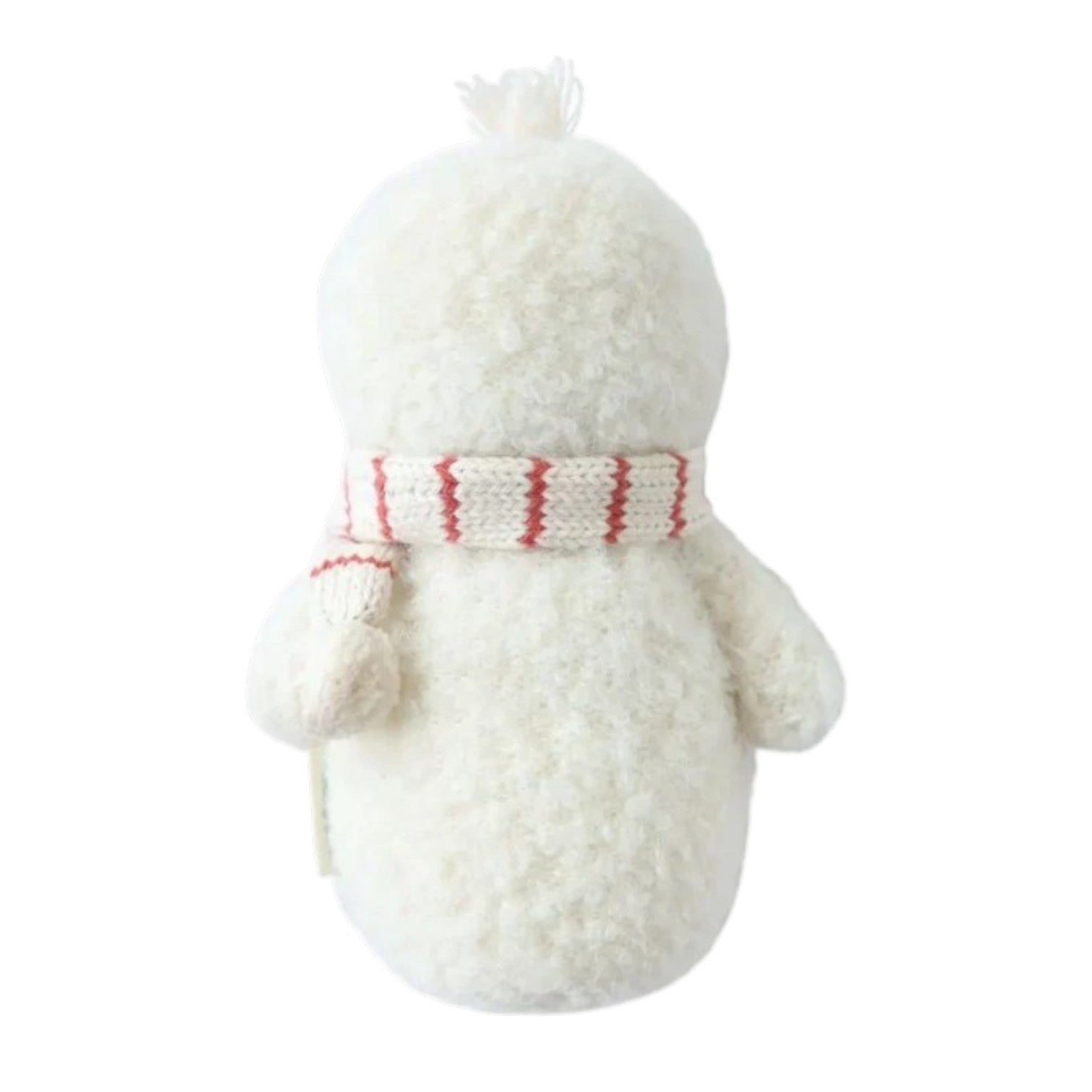 The Cuddle + Kind Baby Snowman - Candy Cane, handcrafted from cotton yarn, faces away while wearing a white scarf with red stripes against a plain white background.
