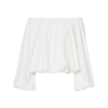 The Soft Volume Shirt by Dorothee Schumacher is a white cotton poplin off-shoulder top with long, loose sleeves, a gathered elastic neckline, and delicate gathered trims.
