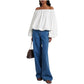 A person wearing the Dorothee Schumacher Soft Volume Shirt, wide-leg blue jeans, black sandals, and carrying a brown handbag.