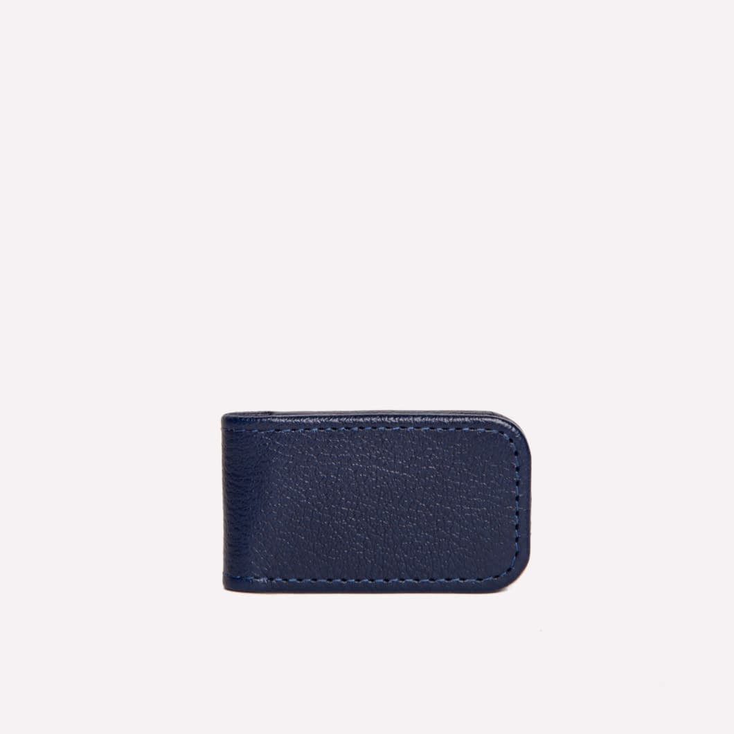 The Ettinger Capra Magnetic Cash Clip, made from navy blue goat leather in a small rectangular shape, is centered on a plain light background.