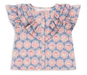 The Konges Slojd Baby Girls’ and Girls Kim Frill Shirt is a short-sleeved blue blouse made from soft organic cotton, adorned with a pink and white floral print, front buttons, and delicate frill detailing on the shoulders and chest.