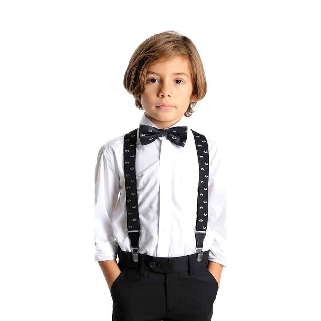 A young boy dressed formally in an Appaman Boys' Standard Longsleeve Shirt, black pants with suspenders, and a patterned bow tie, standing against a white background.