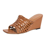 The Staud Blair Woven Wedge by Staud is a brown wedge sandal with an open toe and a woven lattice design, featuring a braided trim, wedge heel, and offering moderate heel height.