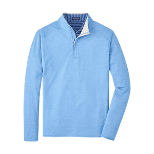 The Peter Millar Stealth Performance Quarter Zip is a light blue long-sleeve pullover with four-way stretch, moisture-wicking fabric, a stand-up collar with striped lining, and quarter-zip design, shown on a white background.