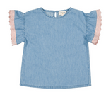 The Loli Chambray Tunic by Louis Louise is a light blue short-sleeve top with ruffled sleeves and pink lace trim along the edges, displayed laid flat on a white background.