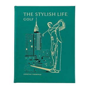The Stylish Life: Golf" by Graphic Image is a green hardcover coffee table book, featuring a gold-outlined golfer and city buildings on the cover—an ideal gift for golf lovers.