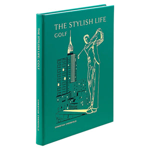 A green hardcover coffee table book, "The Stylish Life: Golf" by Christian Chensvold from Graphic Image, features a golfer and city buildings—an ideal gift for golf enthusiasts.