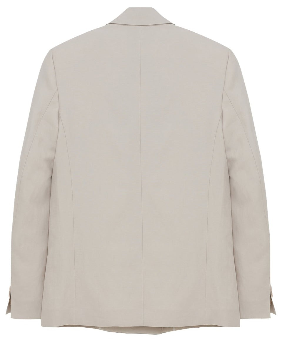 The Dorothee Schumacher Summer Cruise Jacket, a lightweight beige blazer, is displayed from the back. This linen blend jacket features long sleeves and a tailored fit, with visible seams running vertically down the back, making it perfect for summer suiting.