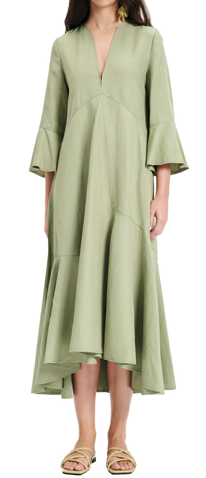 A person wearing a long-sleeved, olive green, V-neck Dorothee Schumacher Summer Cruise Maxi Dress with asymmetrical hemline and ruffled cuffs by Dorothee Schumacher. The linen blend dress features beige sandals, enhancing the overall look.