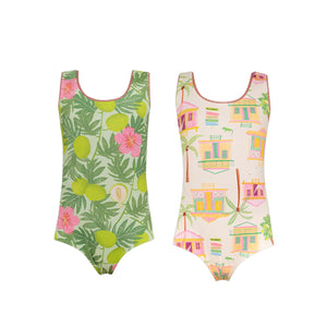 The Pepita & Me Baby Girls' and Girls' Sun & Moon Reversible One Piece offers two kids’ swimsuit styles: one with a green tropical leaf and flower pattern, the other featuring a pastel house and palm tree design.