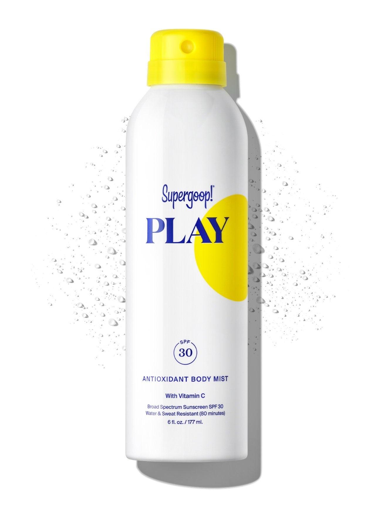 A bottle of Supergoop Play Antioxidant Mist with Vitamin C SPF 30 sunscreen body spray against a white background, with droplets suggesting it is water-resistant.