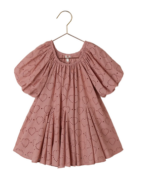 The Noralee Girls' Maia Dress features a pink heart eyelet design, puff sleeves, gathered neckline, and a charming godet skirt, displayed on a gold hanger.
