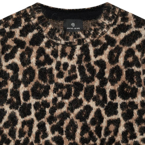 Close-up of the Sydney Crew Sweater by Anine Bing, a heavyweight cotton-blend crewneck with a brown and black leopard print moss stitch and an "ANINE BING" label at the neckline.