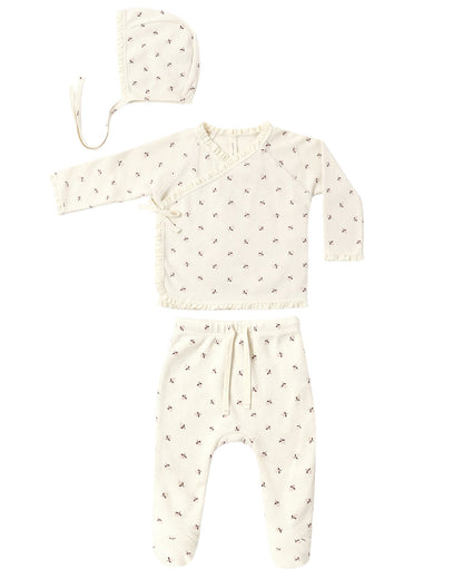 The Quincy Mae Baby Girls’ Take Home Set, shown here in a soft cream waffle fabric with a delicate small bow pattern, features three pieces: a bonnet, a long-sleeve wrap top, and drawstring waist pants. Each piece is laid out flat on a white background—making it the perfect cozy first outfit or take home set for newborns.