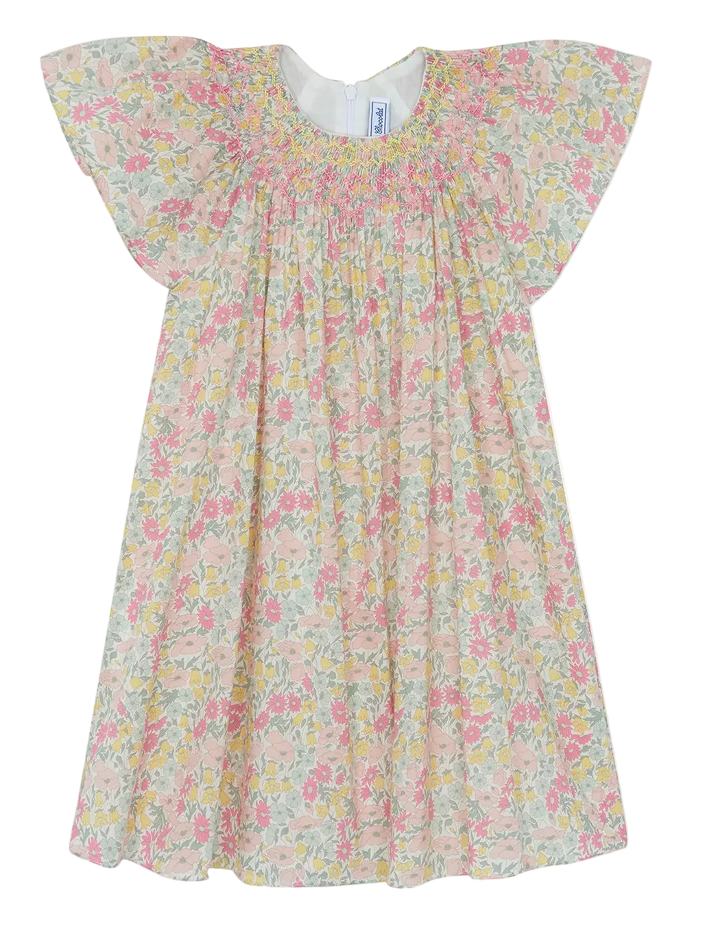 The Tartine et Chocolat Girls’ Liberty Print Dress is a short-sleeved, pastel-colored cotton dress for children, adorned with a delicate smocked collar and a charming Liberty print featuring pink, yellow, and green flowers on a white background.