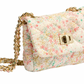 The Milledeux Small Chain Bag, Liberty Print, showcases a colorful star pattern in Liberty of London fabric, enhanced with a gold chain strap and metal closure.