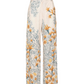 The Florecer Pant by Agua By Agua Bendita is a wide-leg, high-waisted viscose trouser in cream, featuring yellow and blue floral and dotted prints.