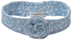 The Fall in Bloom Headband by Kissy Kissy is a light blue, stretchy baby headband featuring a floral pattern, a central fabric flower, and the signature brand label.