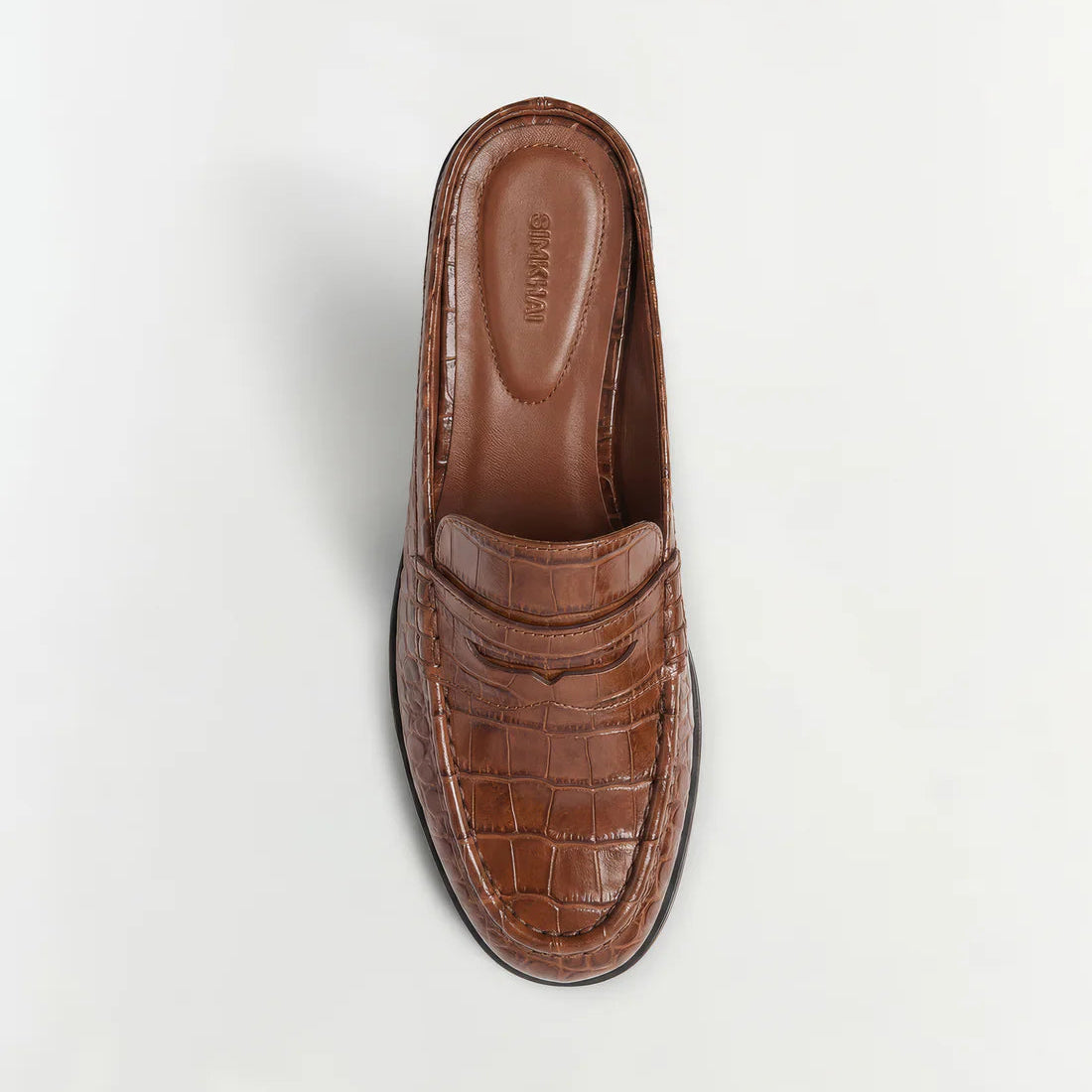 Dean Leather Loafer Mule by Simkhai in brown croc-embossed leather, featuring a closed toe, open back, and raised stitching detail, shown from above on a plain white background.