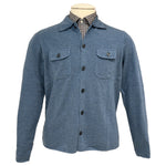 The Alan Paine Tore Cardigan with Pockets, shown on a mannequin over a checkered collared shirt, is a versatile blue layering piece featuring two breast pockets.