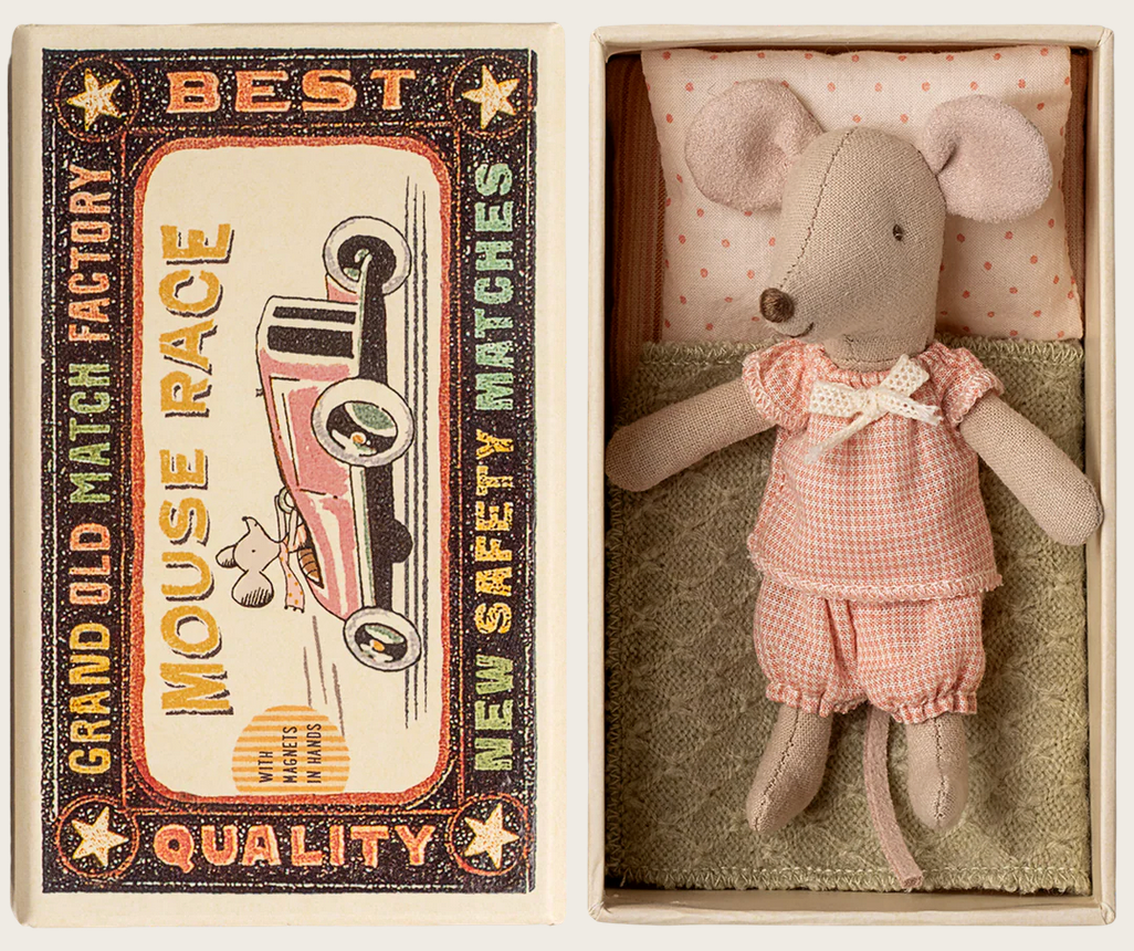 The Maileg Little Sister Mouse, dressed in pink clothes, rests in a charming matchbox bed beside a vintage-style "Grand Old Match Factory" box labeled "Best Quality Mouse Race New Safety Matches.