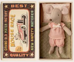 The Maileg Little Sister Mouse, dressed in pink clothes, rests in a charming matchbox bed beside a vintage-style "Grand Old Match Factory" box labeled "Best Quality Mouse Race New Safety Matches.
