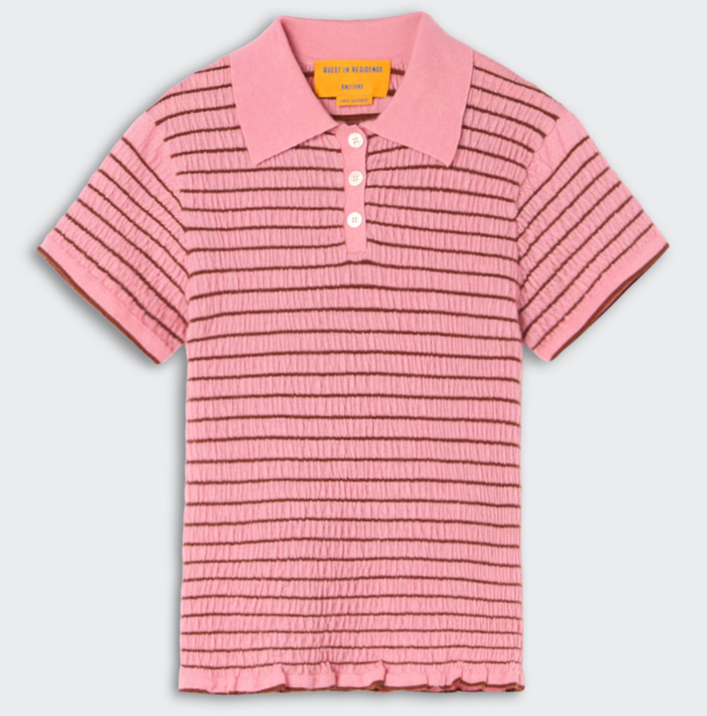 The Smocked Shrunken Polo by Guest in Residence features pink smocked stripe fabric, a slim fit, short sleeves, horizontal brown stripes, and a three-button placket.
