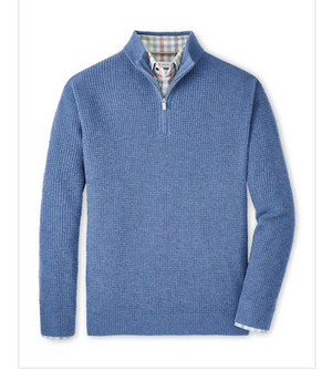 The Crescent Waffle Quarter Zip by Peter Millar, shown in blue wool-yak-cashmere blend with a waffle knit texture, is displayed flat with a plaid shirt peeking out at the collar.