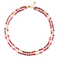 Milos Beaded Necklace featuring double strands of red, pink, and metallic gold beads with a gold lobster clasp, styled like a turquoise and lapis lazuli accessory.