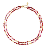 Milos Beaded Necklace featuring double strands of red, pink, and metallic gold beads with a gold lobster clasp, styled like a turquoise and lapis lazuli accessory.