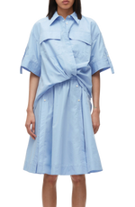 A person in a blue 3.1 Phillip Lim Tucked Front Shirt Dress with short sleeves and a tie waist, designed with an oversized fit.