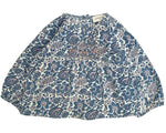 The Baby Girls' Odessette Twill Cashmere Tunic by Louis Louise is a loose-fitting blouse with long sleeves, made from cotton voile, featuring a blue and white floral paisley print and smocked detailing on the chest.