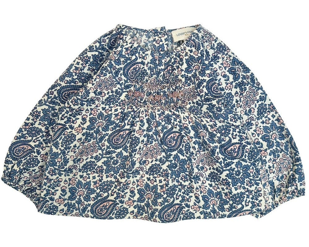 The Baby Girls' Odessette Twill Cashmere Tunic by Louis Louise is a loose-fitting blouse with long sleeves, made from cotton voile, featuring a blue and white floral paisley print and smocked detailing on the chest.