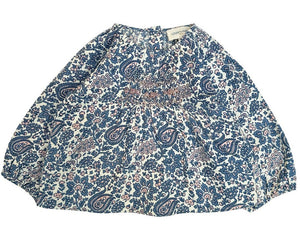 The Baby Girls' Odessette Twill Cashmere Tunic by Louis Louise is a loose-fitting blouse with long sleeves, made from cotton voile, featuring a blue and white floral paisley print and smocked detailing on the chest.