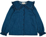 The Louis Louise Girls' Sybillou Light Denim Tunic features chambray blue fabric, long sleeves, front buttons, ruffled cuffs, and a large Peter Pan collar. Shown laid flat on a white background.