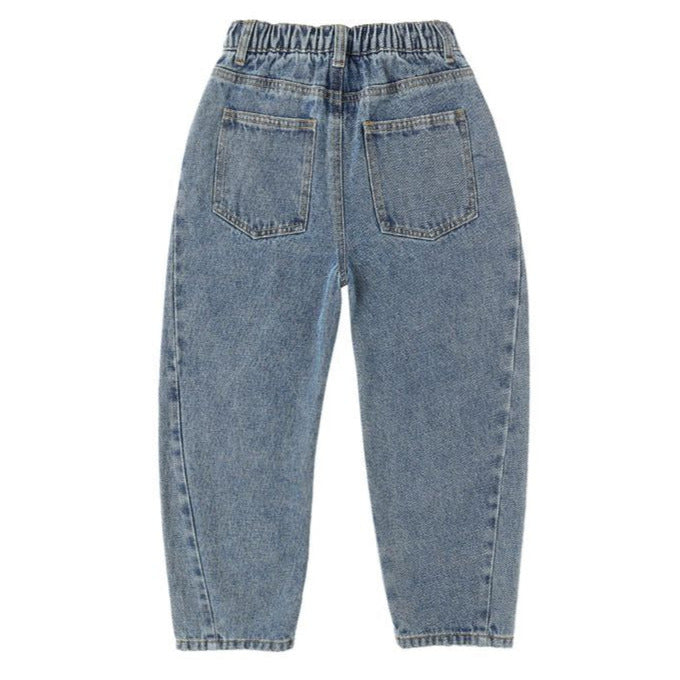 The Girls' Barrel Pant by Rylee & Cru is a blue denim style with an elastic waistband and two back pockets, shown flat with the back side up. Its relaxed fit combines comfort and everyday style.