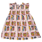 Back-to-school ready, the Girls' Stevie Dress by Pink Chicken is a charming pink children's dress with a smocked bodice and a vibrant juice boxes print on a white background.