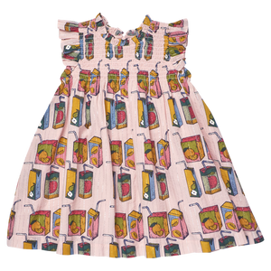 Back-to-school ready, the Girls' Stevie Dress by Pink Chicken is a charming pink children's dress with a smocked bodice and a vibrant juice boxes print on a white background.